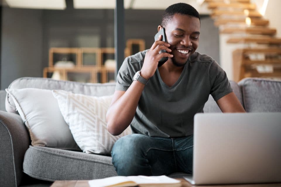 Home inspector taking a client call while working on a laptop