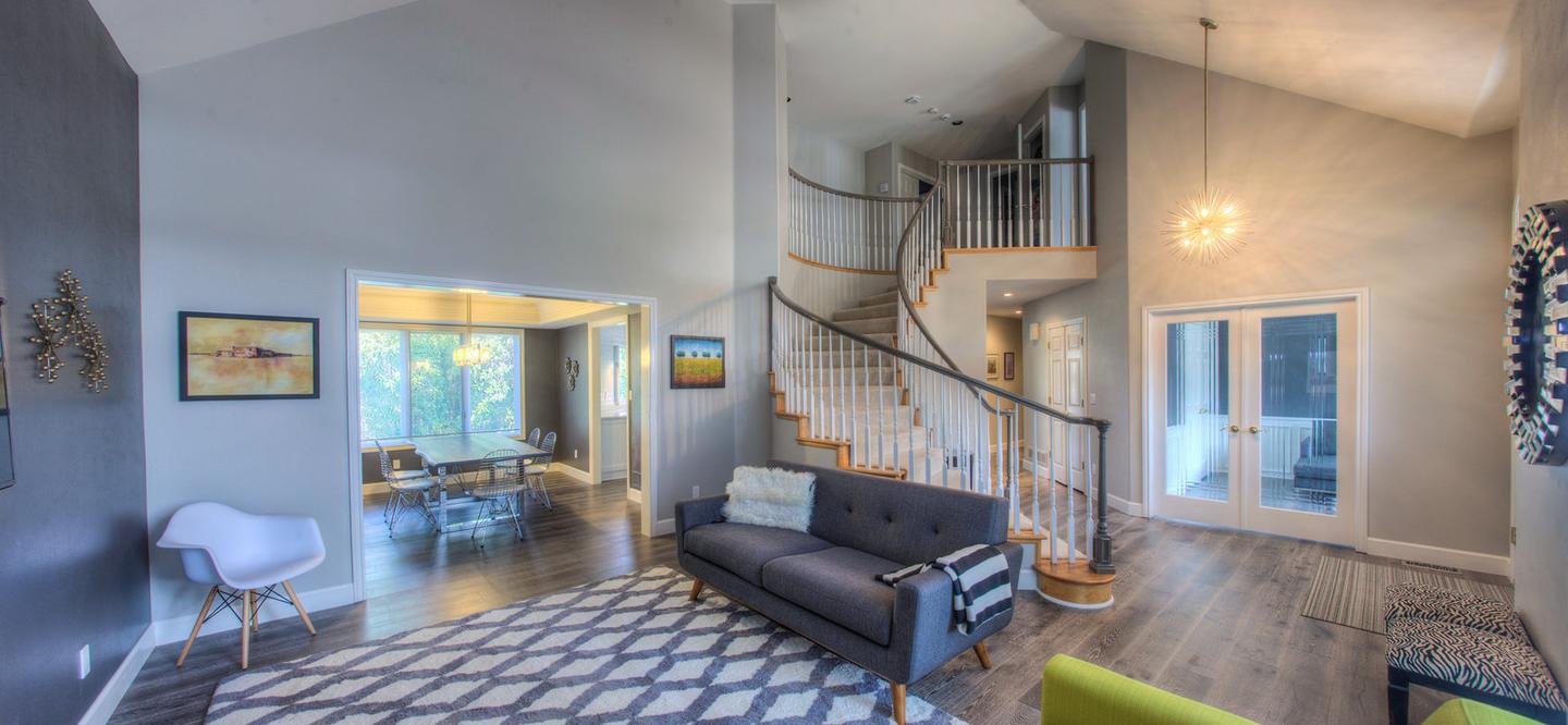 Open-plan living room with a sofa and a curved staircase