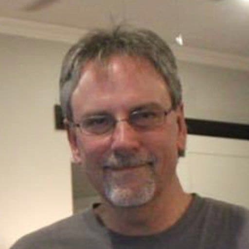 Marlin Wilton, inspector, smiling in a gray shirt with glasses
